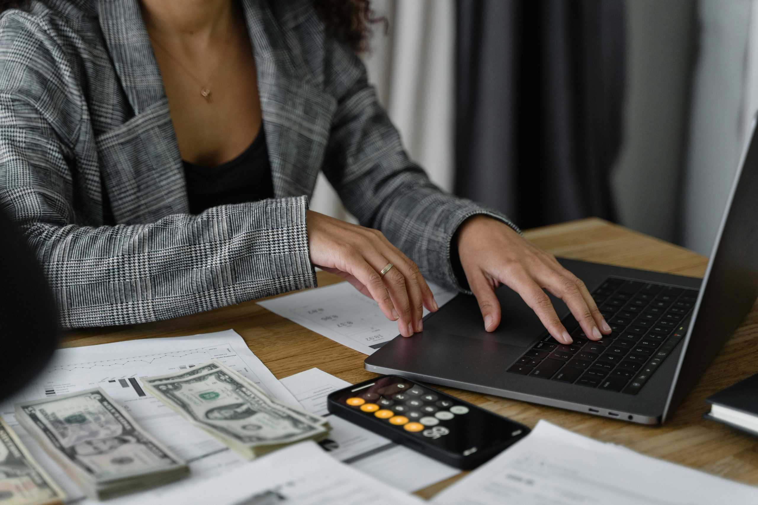 Mujer calculando préstamos hipotecarios en su computadora.