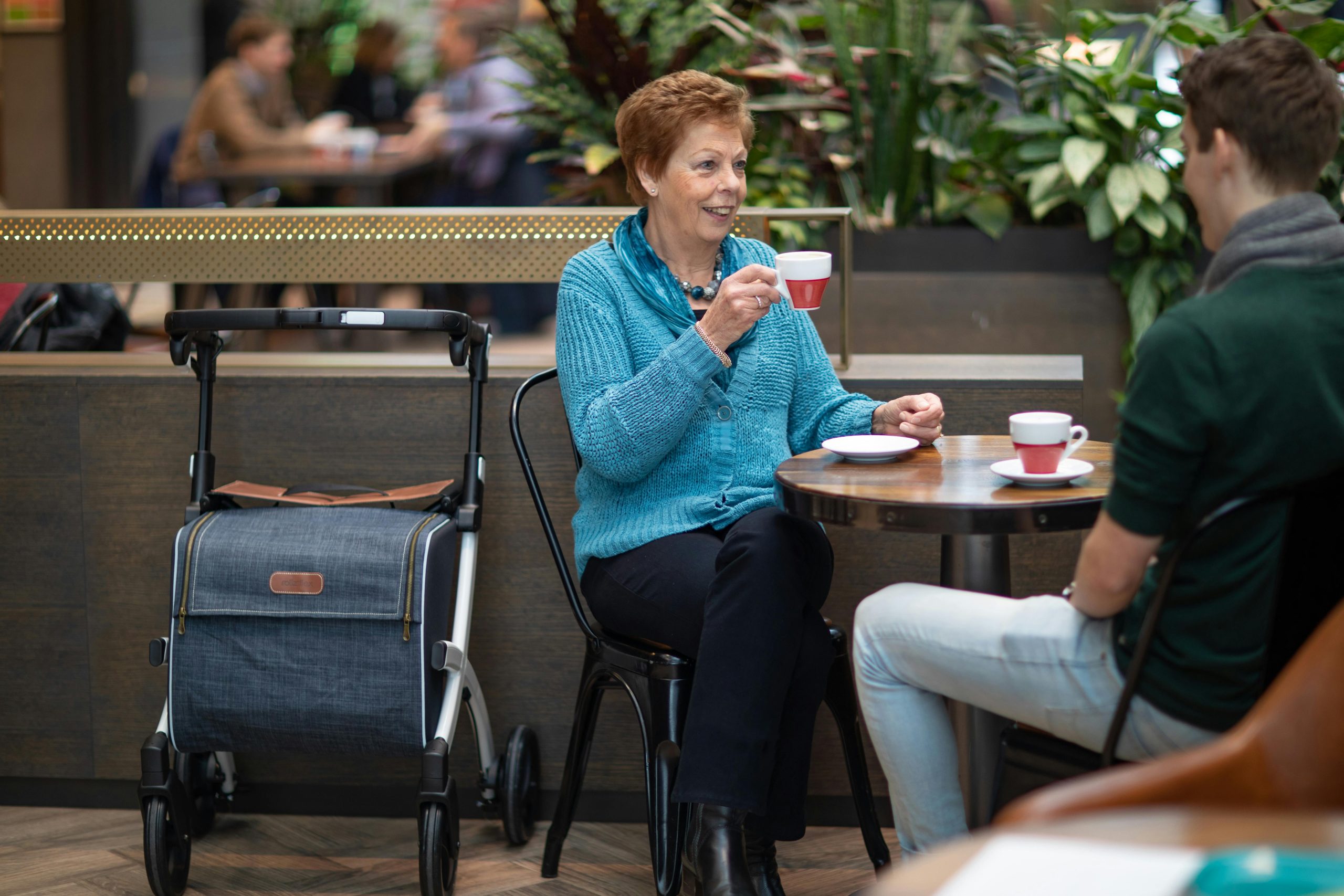 Dos personas sentadas tomándose un café en centro comercial.