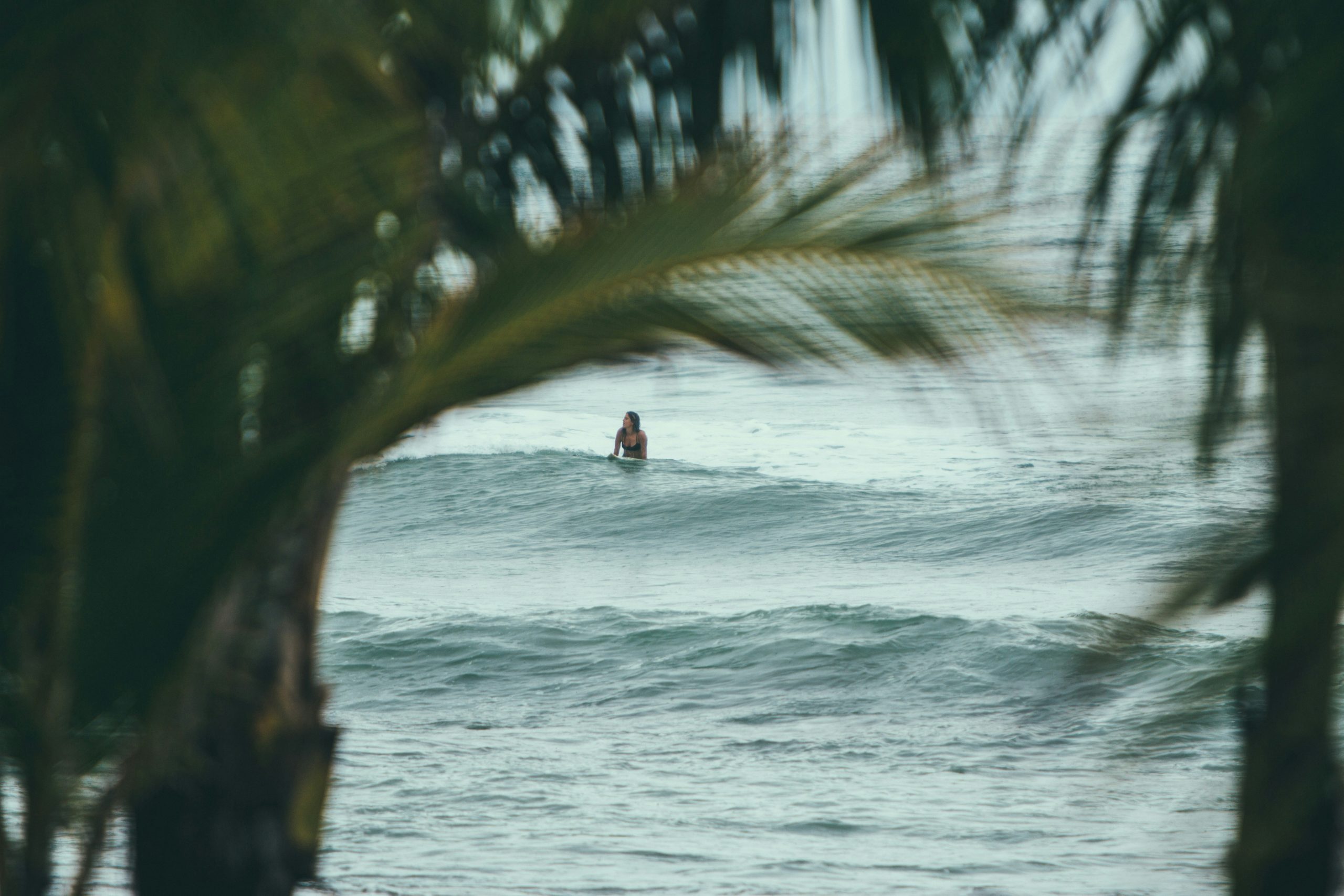 Mujer sobre tabla de surf en el mar.