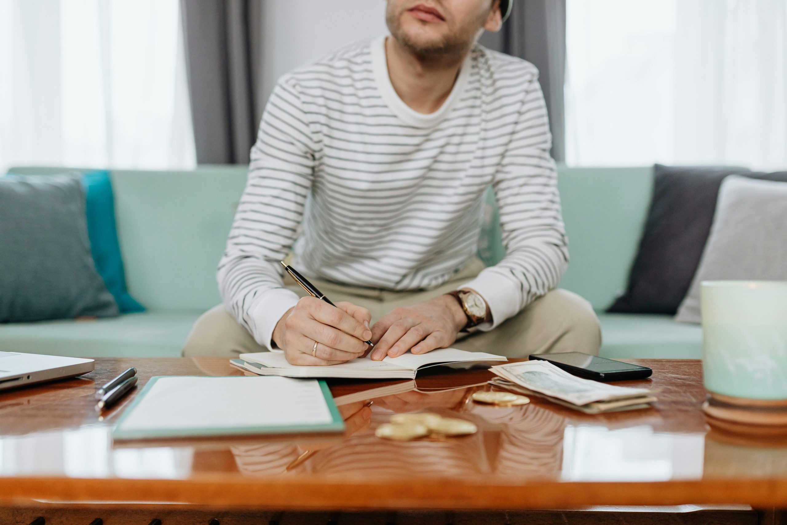 Joven haciendo cálculos financieros en su cuaderno.