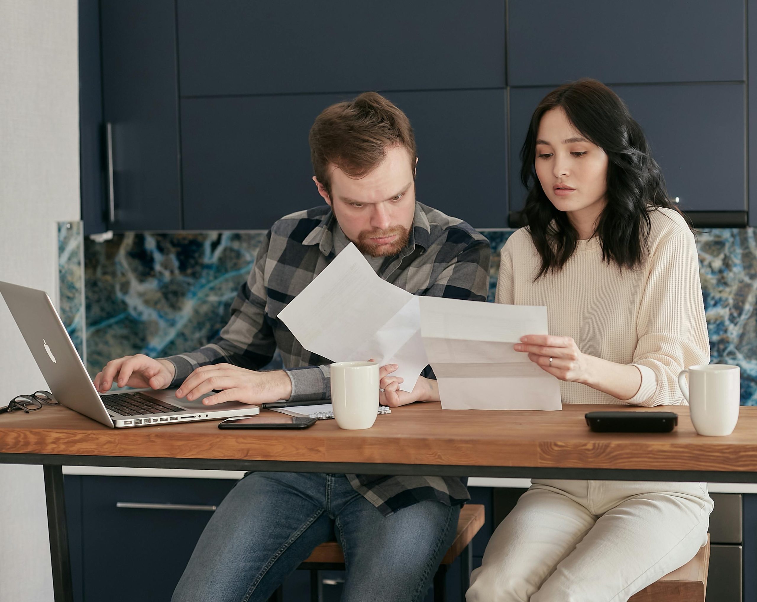 Pareja revisando documentos financieros en casa
