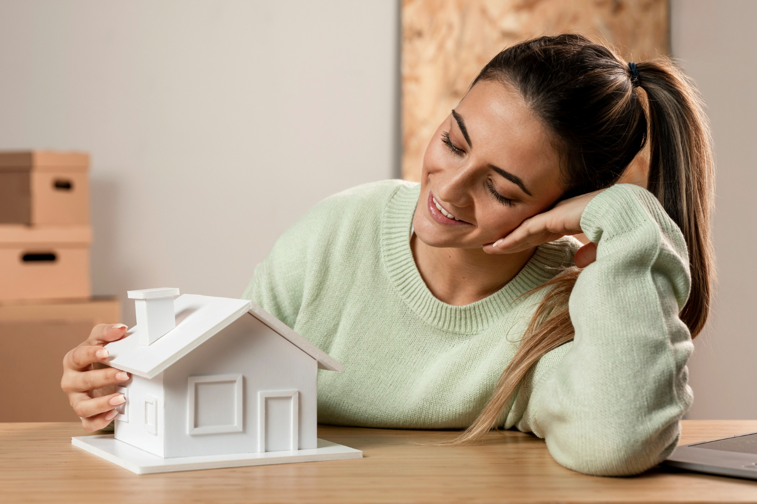 Joven feliz mirando una maqueta de una casa