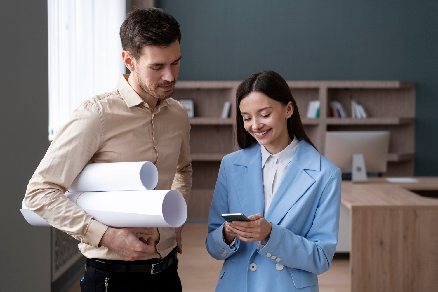 Mujer y hombre mirando el celular con planos
