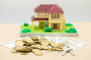 Maqueta de casa, monedas, billetes y llave