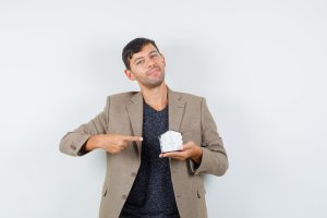 Hombre con maqueta de casa en al mano