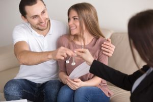 Pareja feliz recibiendo llaves de casa